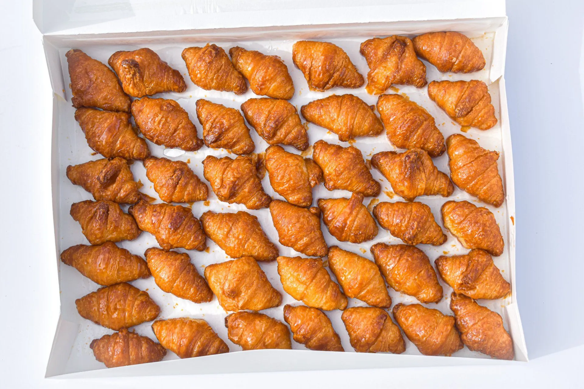 Bandeja de mini croissants con glaseado dorado